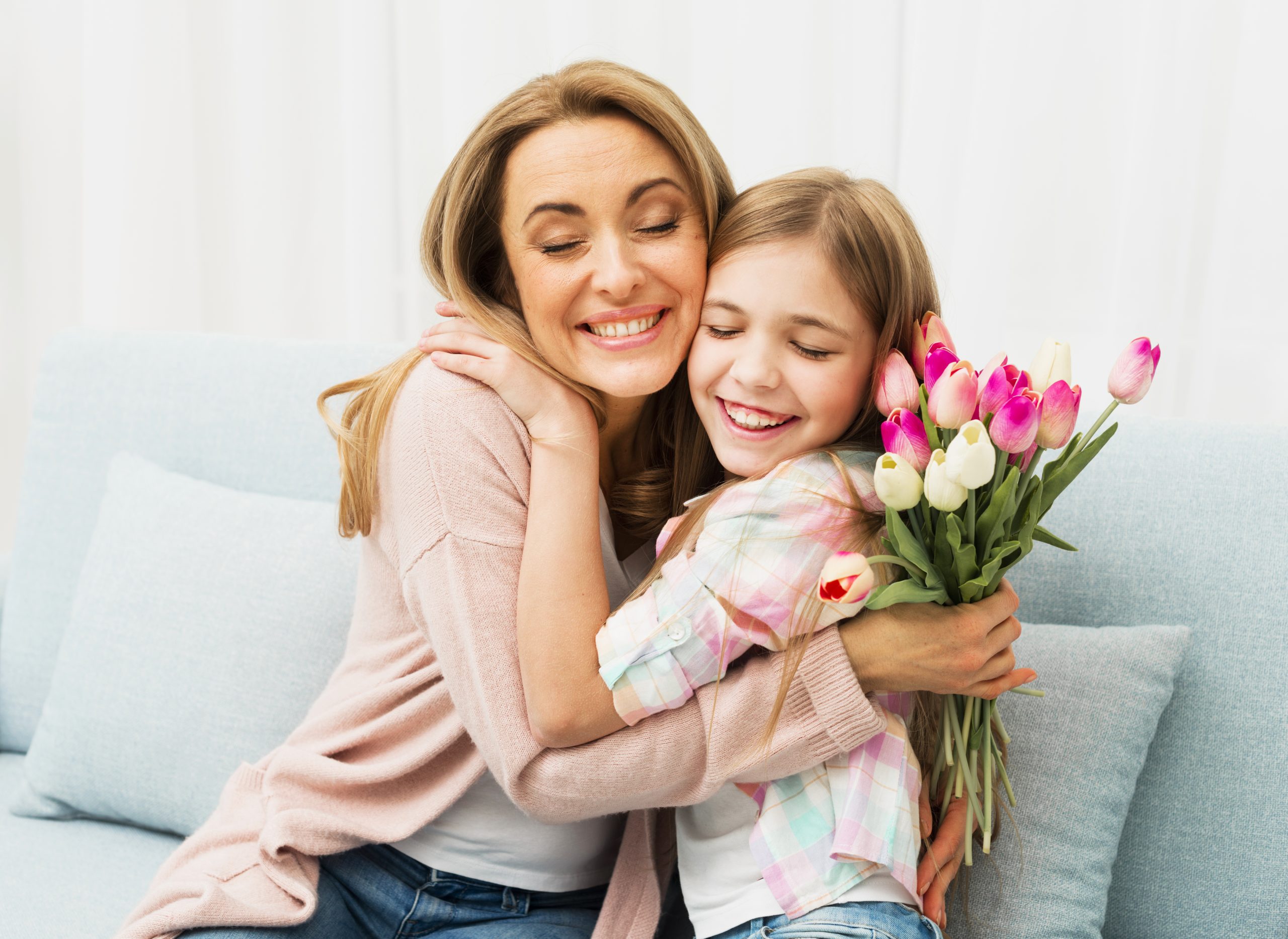 Girl hugging her mother after giving the mothers'day gift